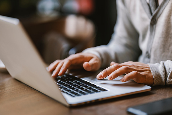 Close up of hands typing on a laptop at a desk