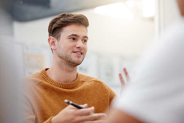 Man in classroom discussing papers